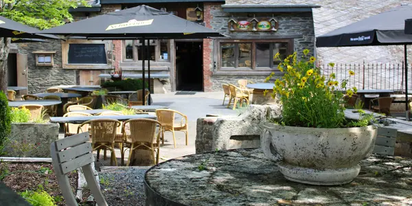 Entrée et terrasse ombragée de La Petite Fontaine à Achouffe